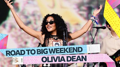 Artwork for Road to Big Weekend, featuring a picture of Olivia Dean performing onstage.