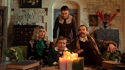A group of four people dressed in old clothes sat in a lounge of a castle