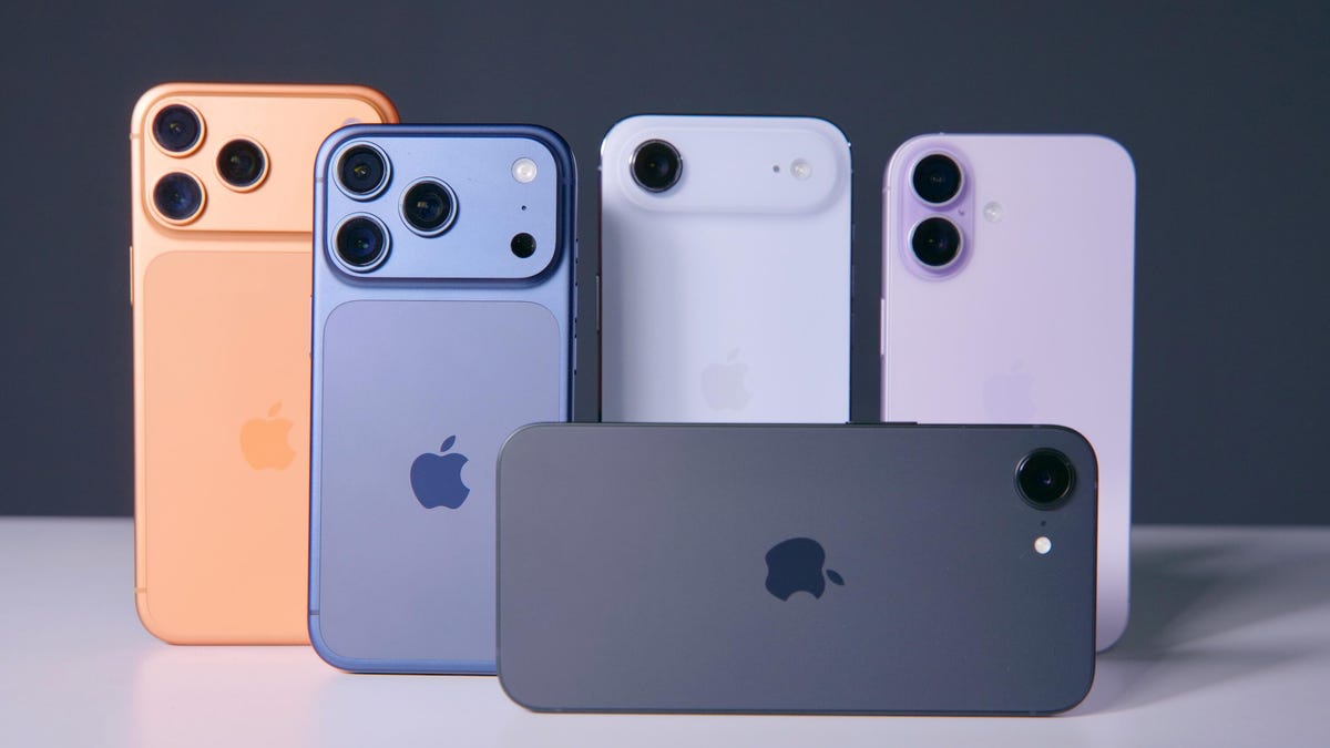 Five iPhone models standing on a white table