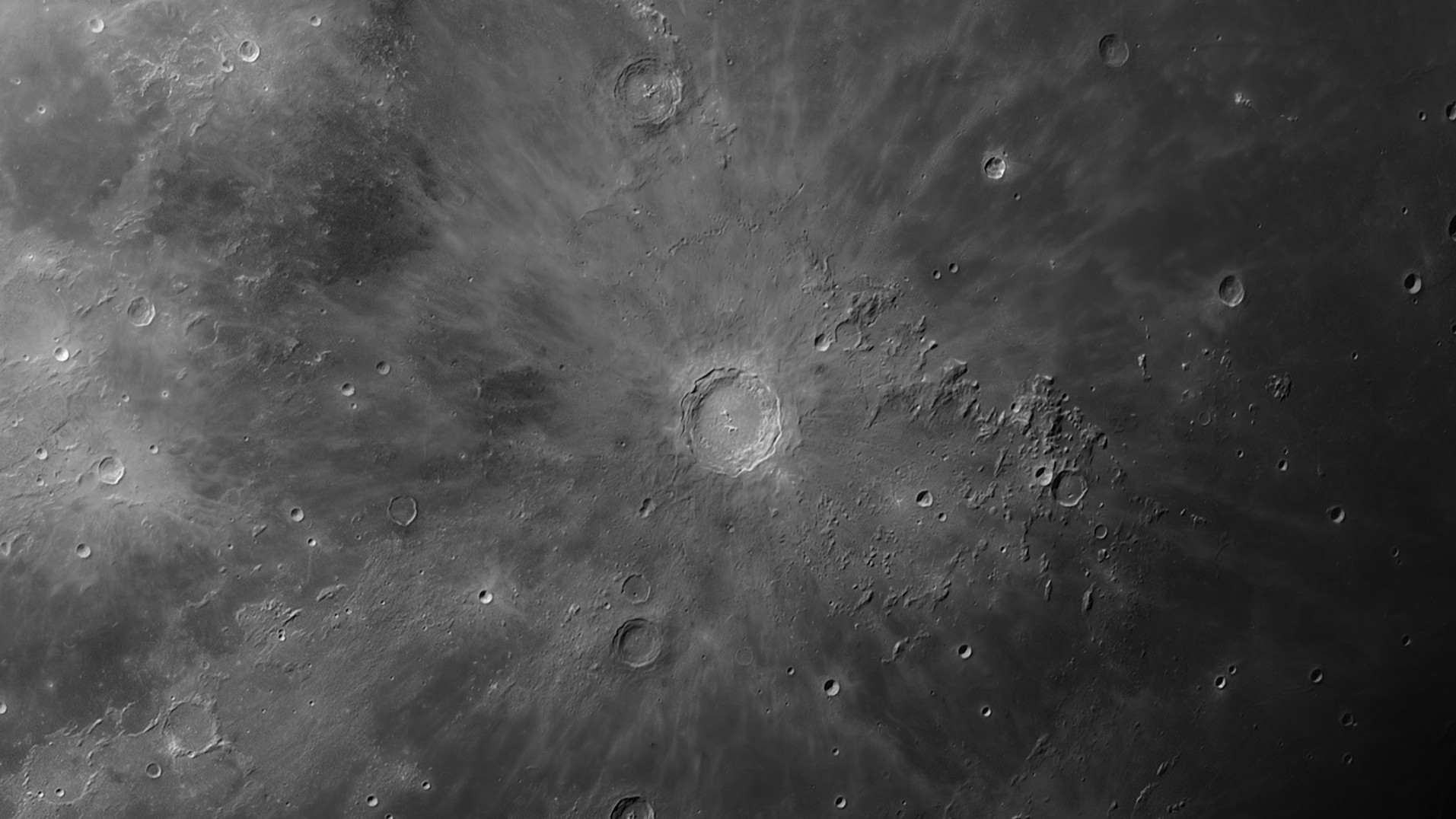 close up view of copernicus crater surrounded by smaller craters on the moon.