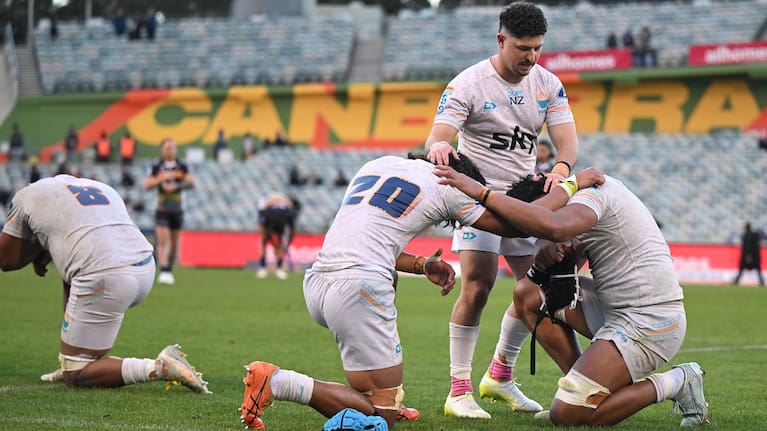 Patrick Pellegini (standing) celebrates Moana Pasifika's victory over the Brumbies with his teammates.