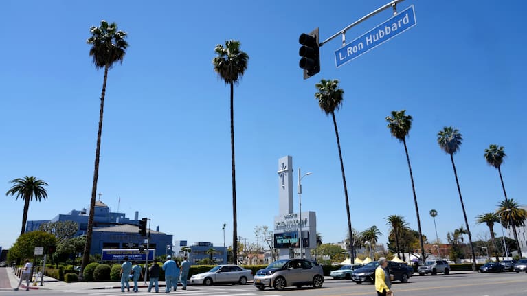 Pedestrians pass underneath a street sign for L Ron Hubbard Way in front of The Church of Scientology of Los Angeles, April 21, 2023, in Los Angeles.