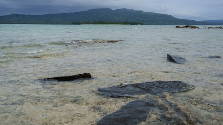 Gravestones sit submerged in water on Pele Island, Vanuatu, a country heavily affected by rising seas July 18, 2025.