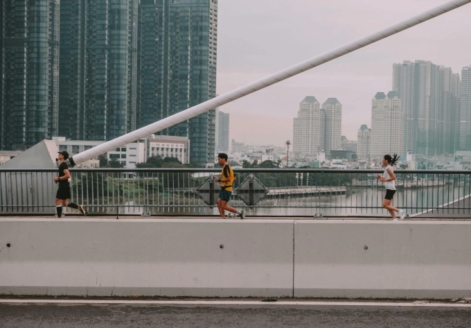 People run on a bridge in Ho Chi Minh City. Photo by Pexels/Duy Nod