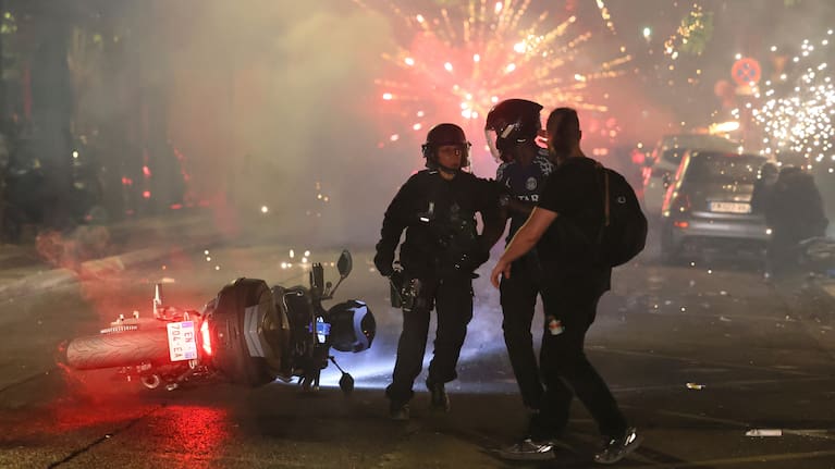 Police try to disperse PSG supporters who left off fireworks as they celebrate in Paris, Saturday, May 30, 2026.