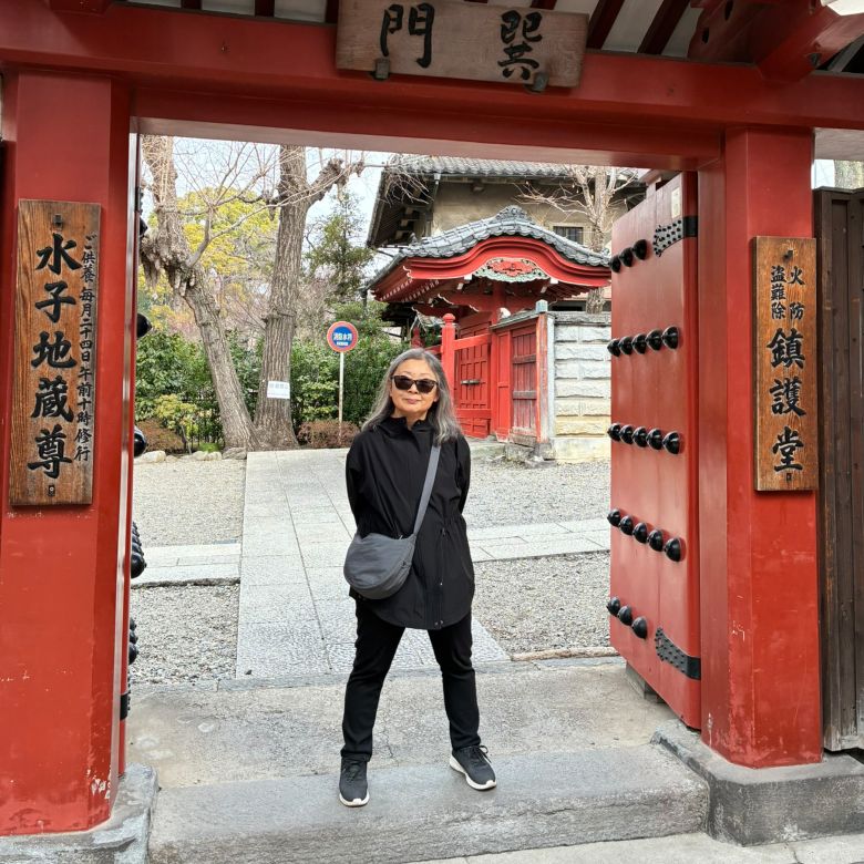 Jane Nagai stops at one of the side entrances to Senso-ji temple in Tokyo, Japan. She and her husband, Ray Caesar, visited in February 2026 in lieu of a trip to New York.