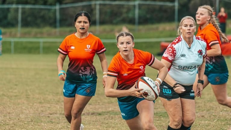 Rebecca Stanaway referees a rugby game. 
