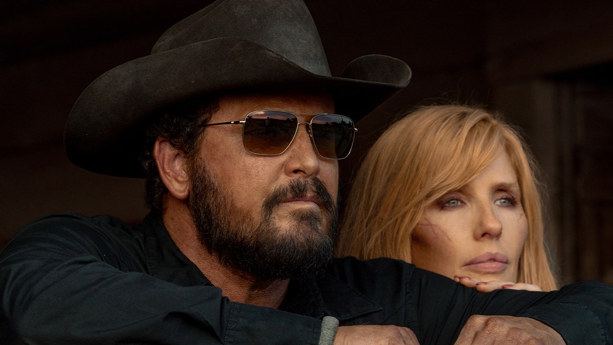 Cole Hauser and Kelly Reilly standing together in character as Rip and Beth Dutton