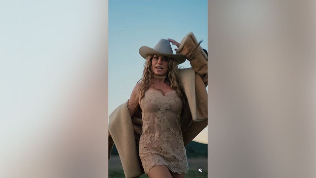 Shania Twain dancing in a field in a nude dress with lace in a recent Instagram post.