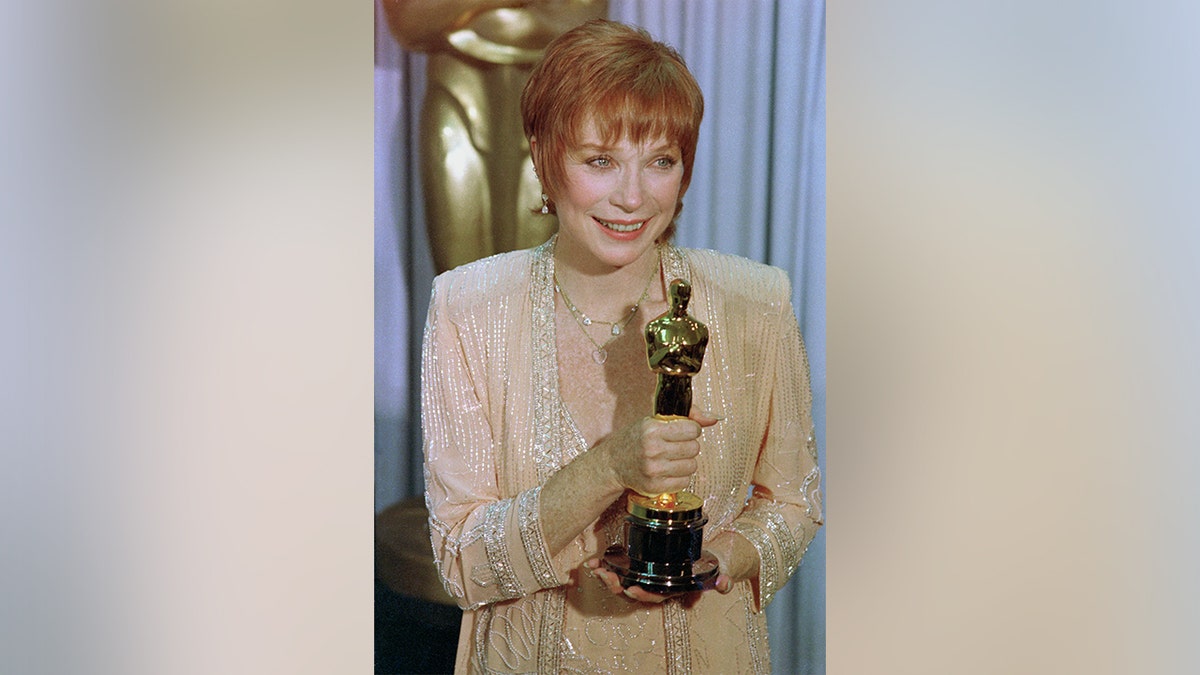 Shirley Maclaine standing on stage at the Oscars ceremony.