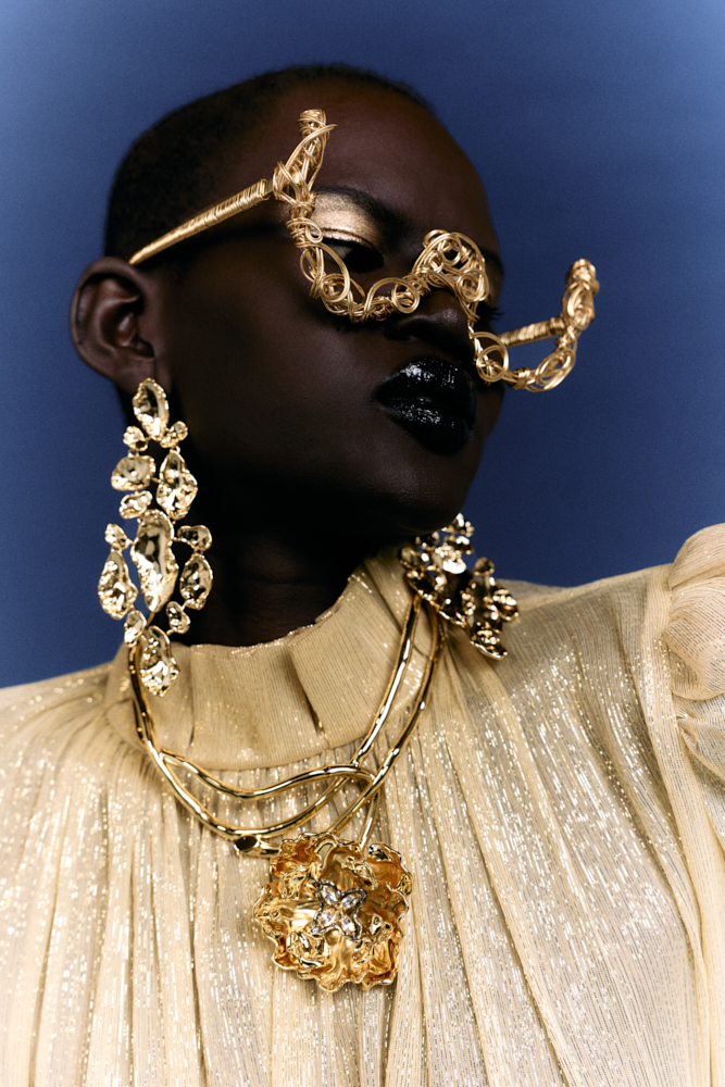 Model in gold wearing facepiece