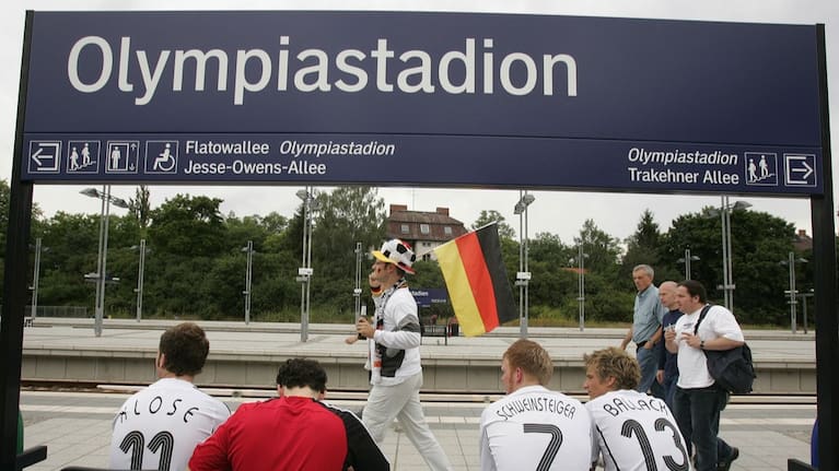 Soccer fans one carrying the German flag, arrive at the Olympiastadion station in Berlin, Friday, June 30, 2006.