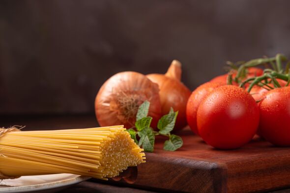 Spaghetti, spaghetti placed alongside other complements in a dark kitchen on rustic wood, selective focus. Spaghetti, spaghetti placed alongside other complements in a dark kitchen on rustic wood, selective focus.