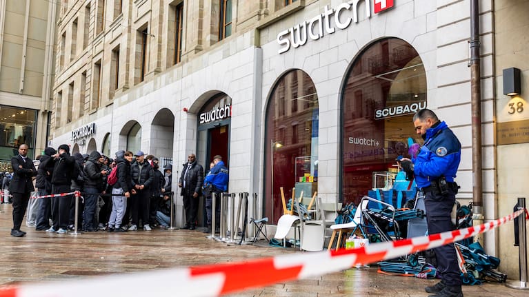 Swiss police officers secure the area where customers queue to buy the new Royal Pop watch by Swatch and Audemars Piguet