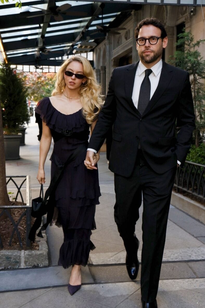Sydney Sweeney and Scooter Braun holding hands while dressed formally
