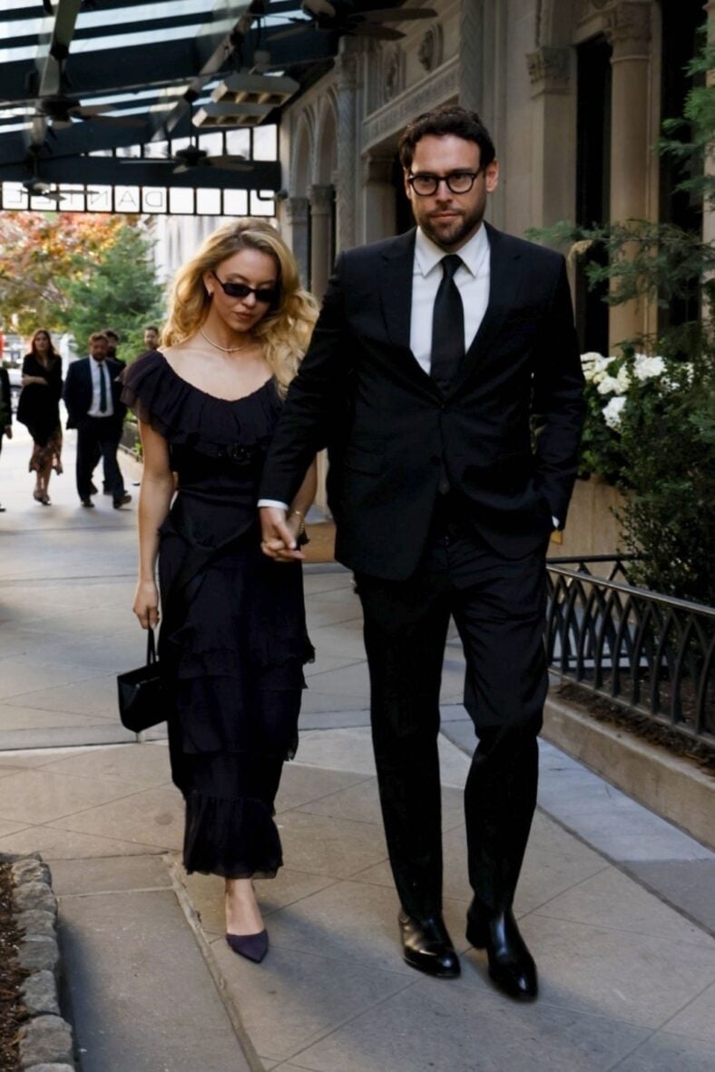 Sydney Sweeney and Scooter Braun holding hands while dressed formally