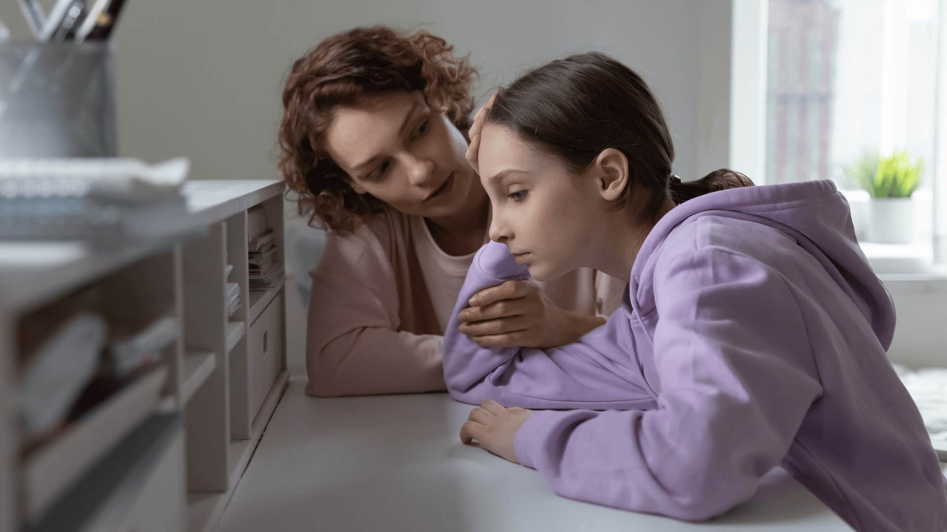 woman comforting upset teen girl unable to afford tuition for college