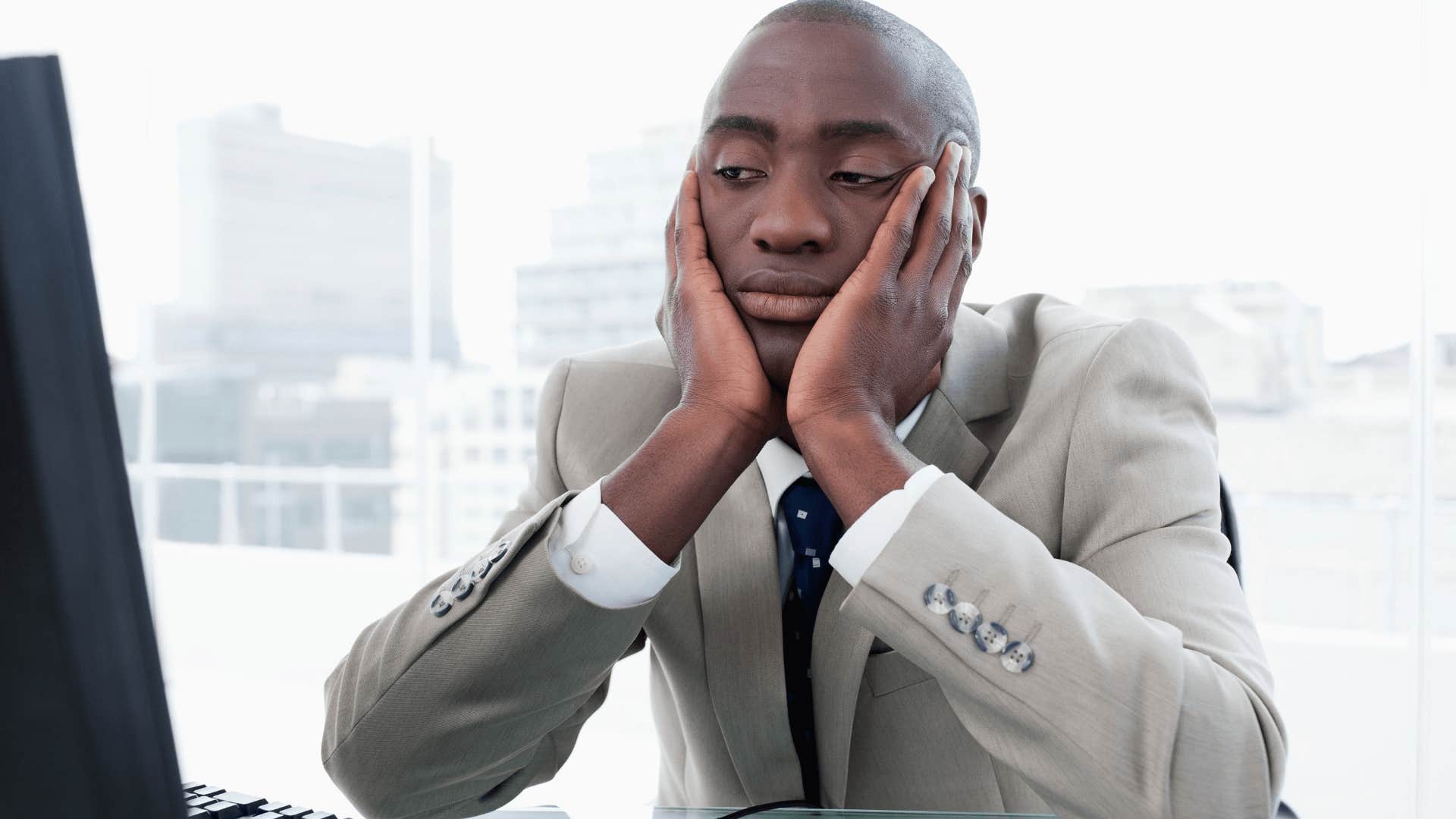 stressed man who can't retire sitting at work