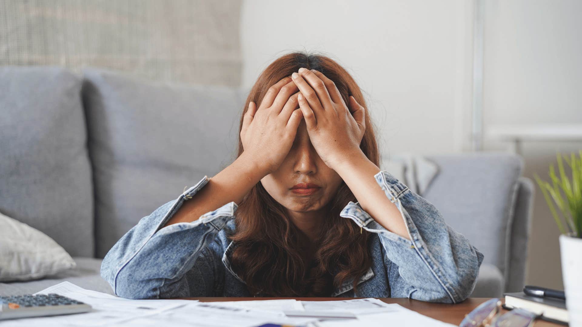 upset woman worried about money looking at bills