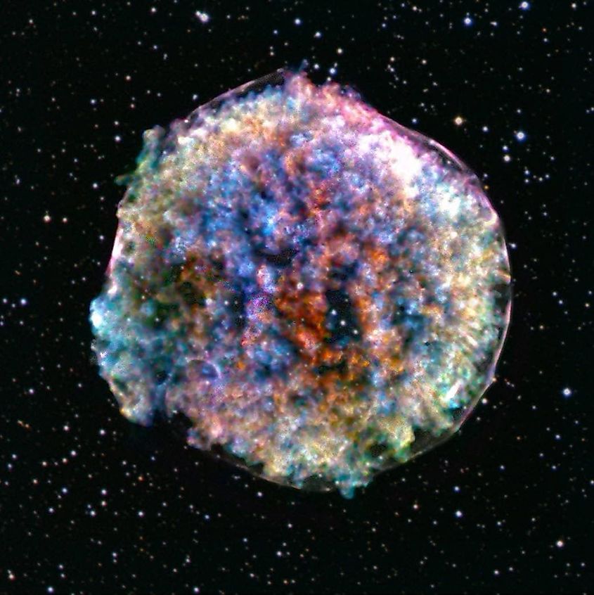 The remnant of a supernova observed in 1572, notably studied by the Danish astronomer Tycho Brahe, lies about 13,000 light-years away in the constellation Cassiopeia. In this composite image, data from NASA’s Chandra X-ray Observatory have been combined with an optical image of stars in the same area. X-ray: NASA/CXC/RIKEN & GSFC/T. Sato et al; Optical: DSS