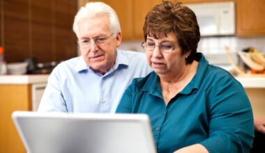 Two people at a laptop with serious expressions.