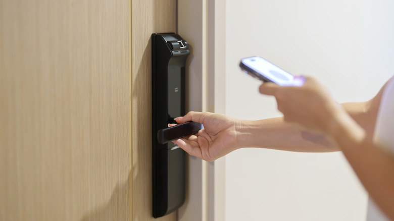 Person using smartphone to open door