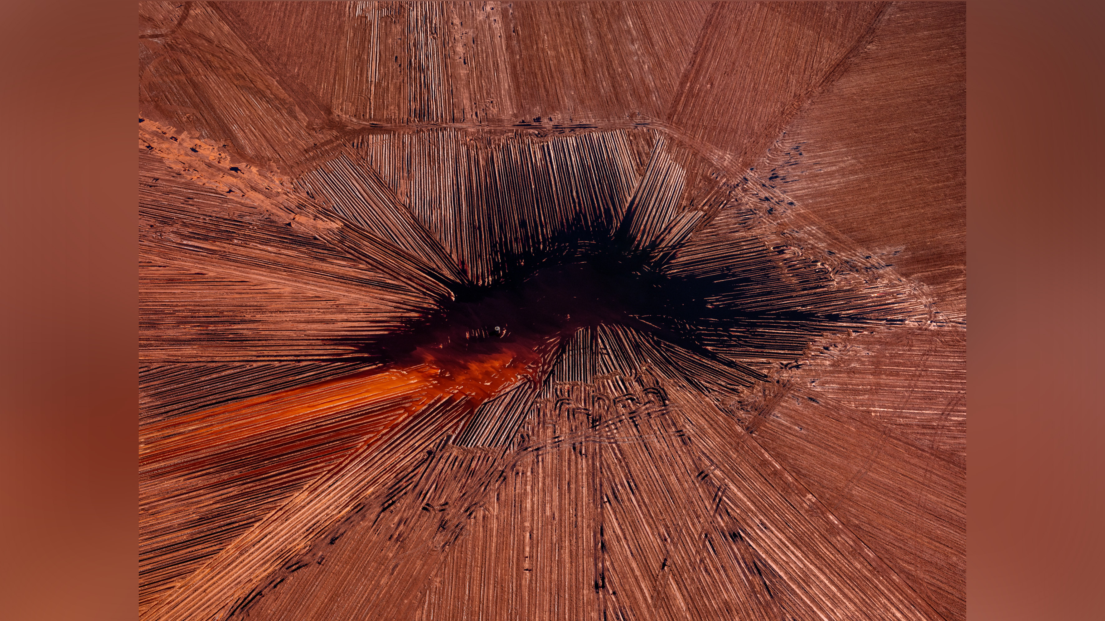 Colorful patterns in landscapes caused by industrial mining.