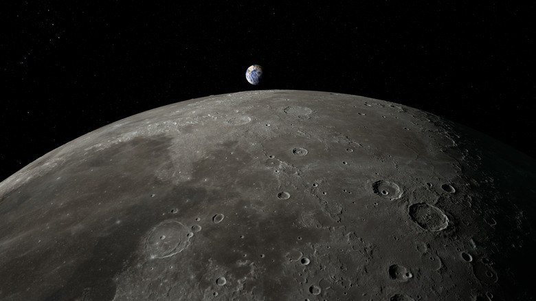 An impact crater on the Moon with the Earth in the background