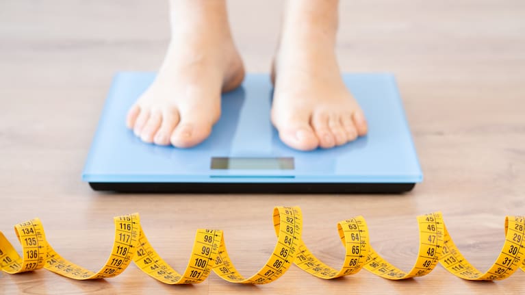 Woman measuring her weight on the scale stock photo.