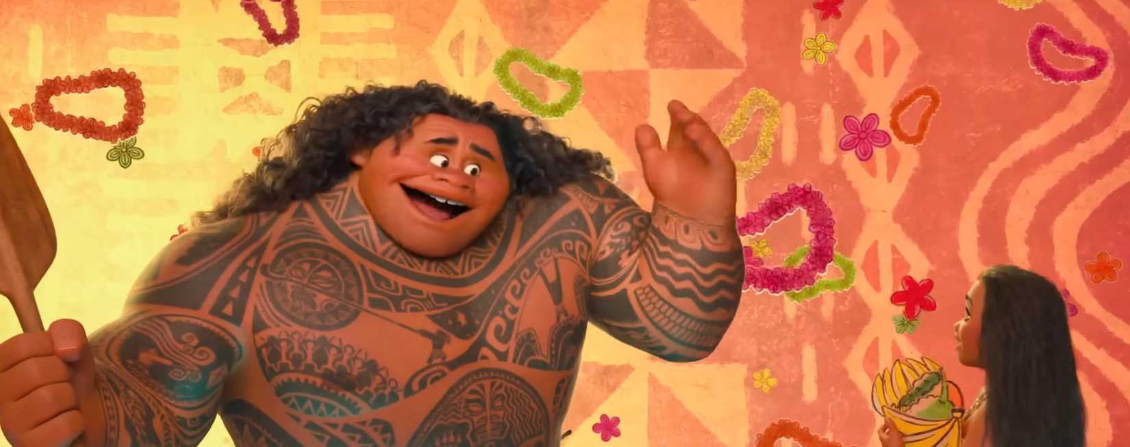 Maui, a hugely muscled, shirtless man covered in tattoos, sings to teenage Moana with a backdrop of stylized cartoon leis and flowers in the 2016 animated Moana