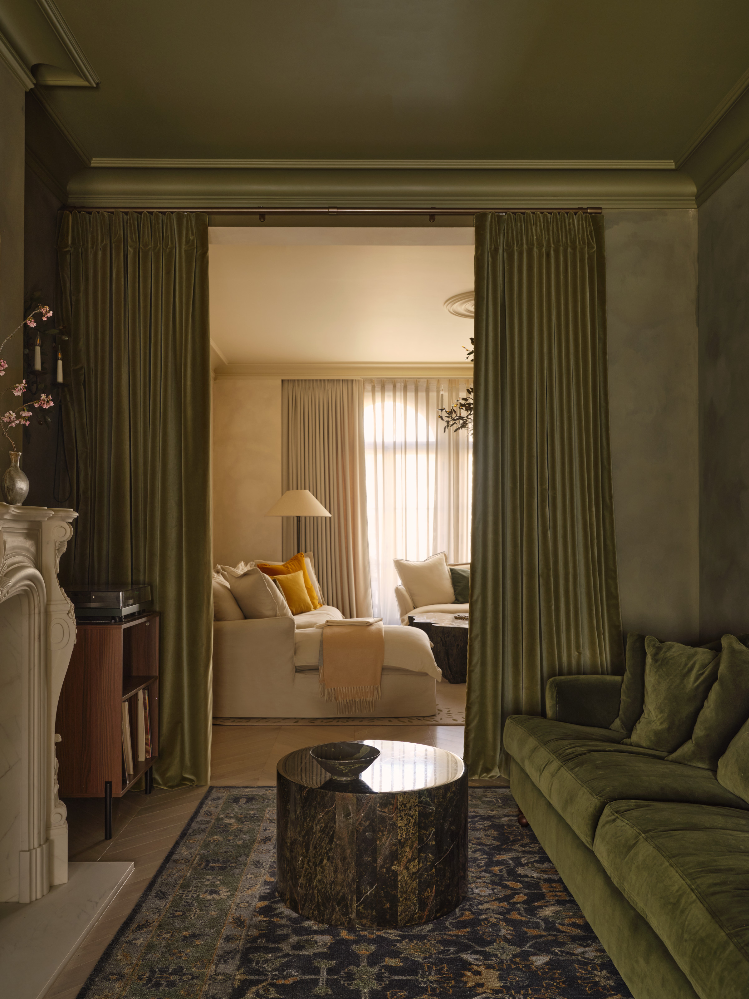 Olive green snug with velvet sofa and curtains and textured walls