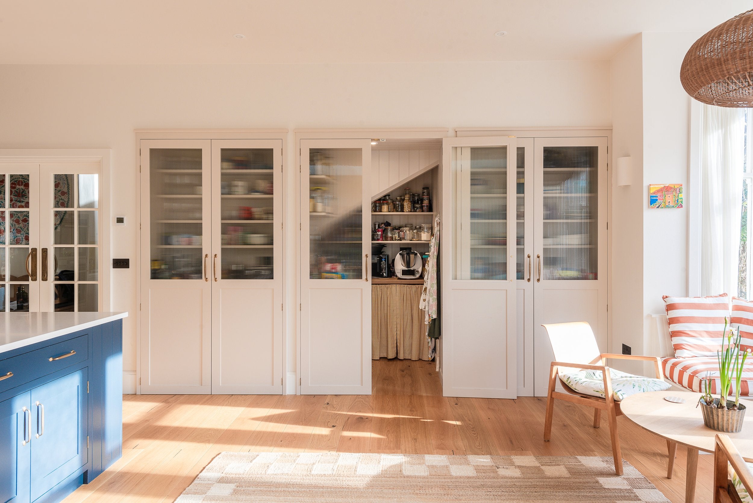 A walk-in pantry and breakfast station sit neatly behind a wall of cabinetry, showing how smart storage can help every inch of a kitchen work harder (Herringbone Kitchens/PA)