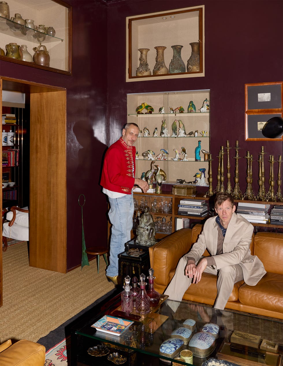 Two men in a room with a collection of decorative items and ceramics.
