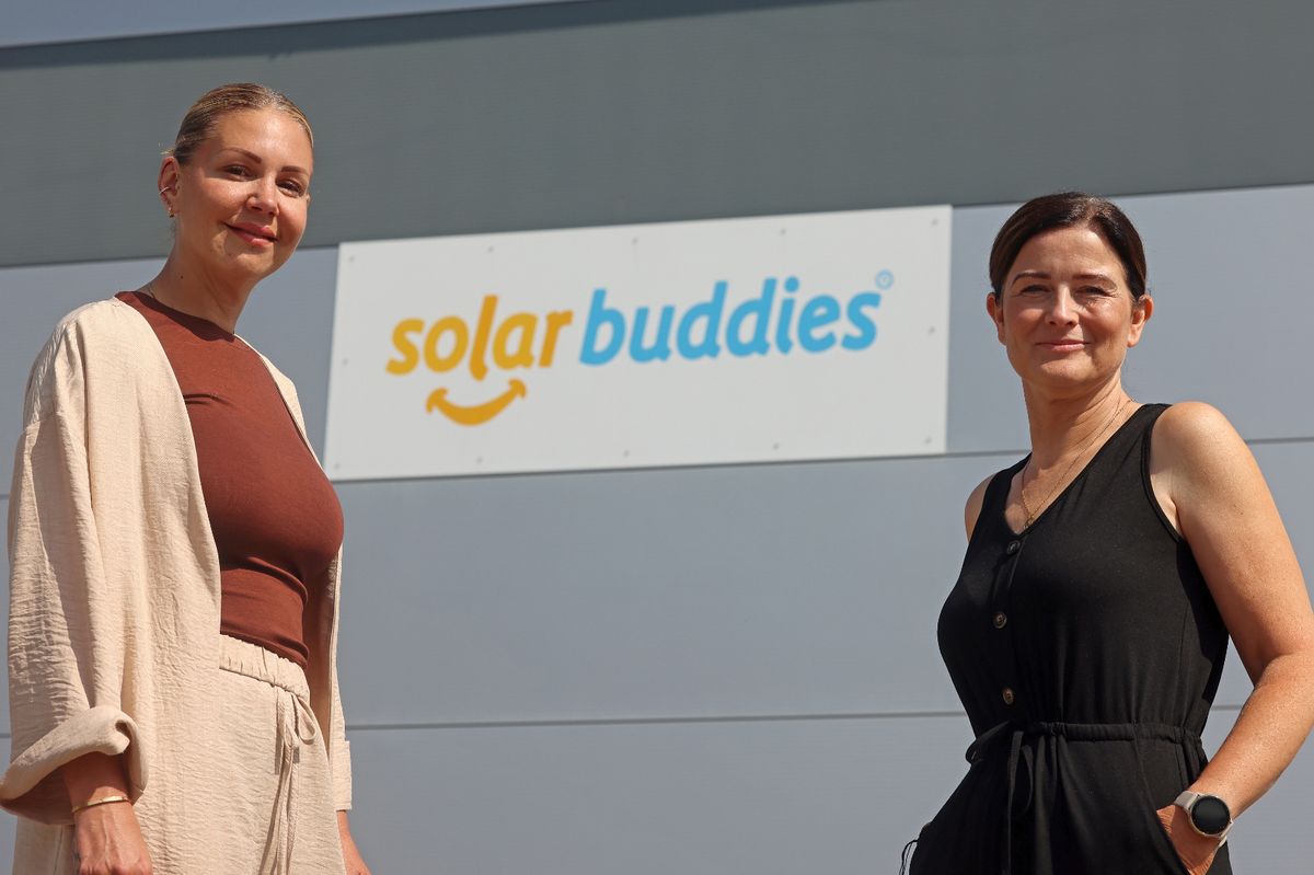Two women stood near a Solar Buddies sign
