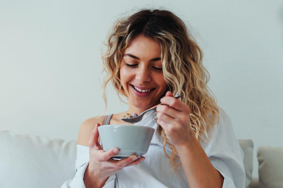 Woman eating healthy breakfast at home in morning