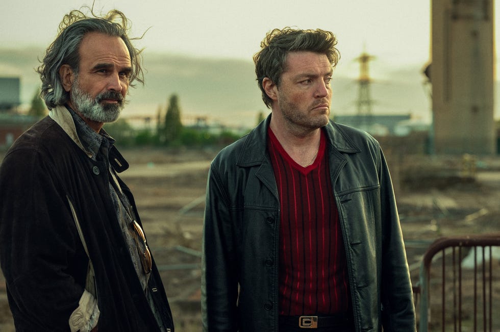 Gerald Kyd and Tom Burke as Mylonas and Guy in Netflix's Legends .jpg gerald kyd and tom burke as mylonas and guy in netflix's legends standing together outside