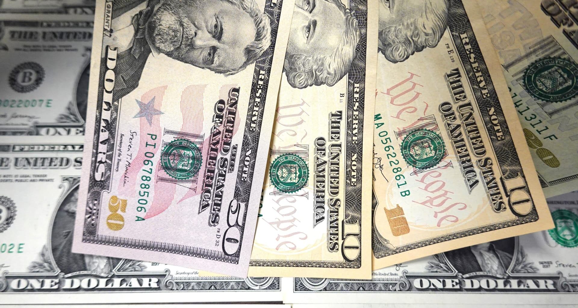 Dollar eases from 13-month high after burst of economic numbers