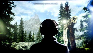 A person silhouetted against a large screen as they play a fantasy video game.