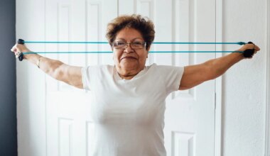 A photo of a senior woman exercising with a resistance band.
