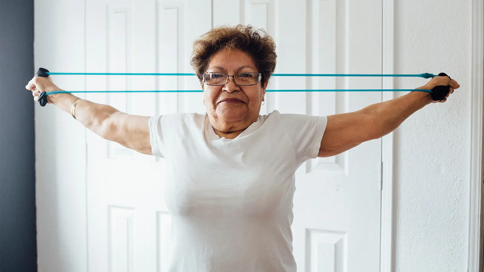A photo of a senior woman exercising with a resistance band.