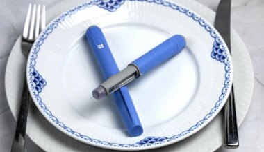 A photo of two semaglutide injection pens lying on a plate between a knife and fork.
