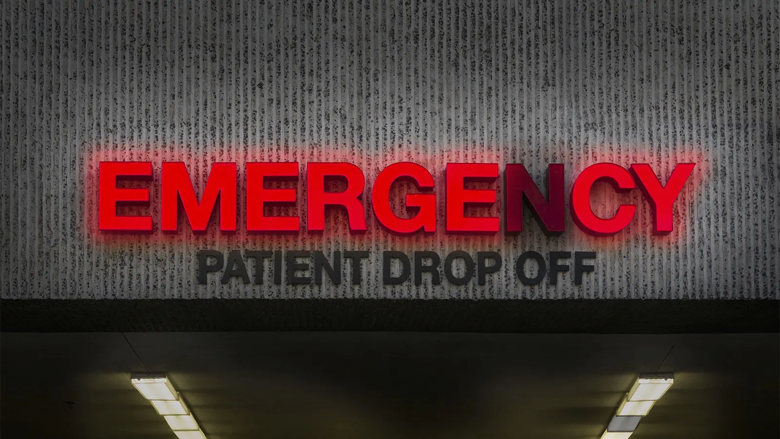 A photo of an illuminated emergency sign on a hospital with the letter N burned out.