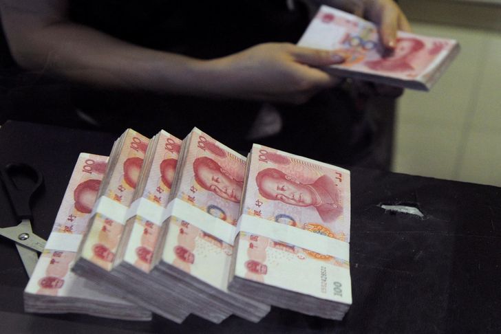 An employee counts Chinese 100 yuan banknotes at a branch of China Merchants Bank in Hefei, Anhui province, June 21, 2013. Reuters-Yonhap