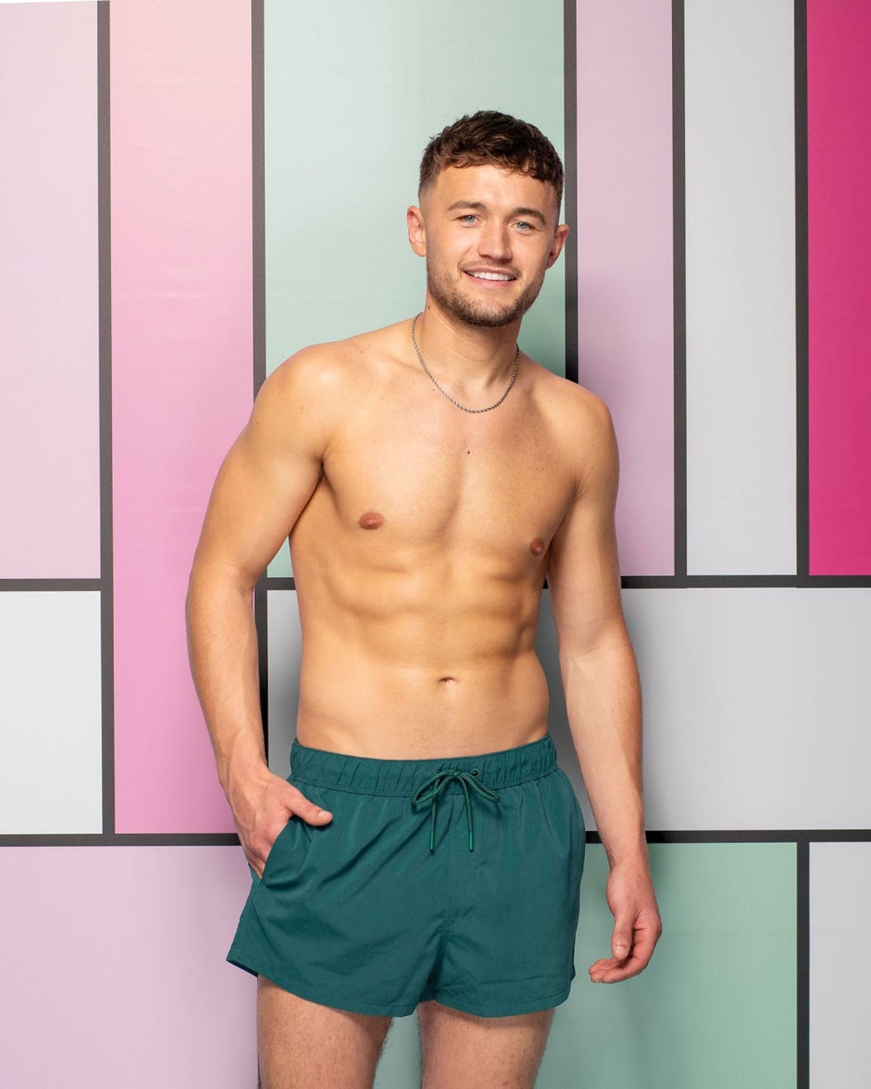 love island 2026 finley man in swim shorts against a colorful geometric background