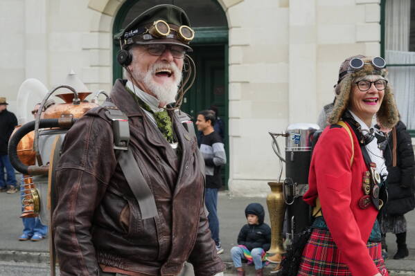 Steampunk NZ Festival co-founders Iain Clark, who goes by Agent Darling, and Helen Jansen walk in a parade at the annual event in Ōamaru, New Zealand, Saturday, May 30 2026. (AP Photo/Charlotte Graham-McLay)