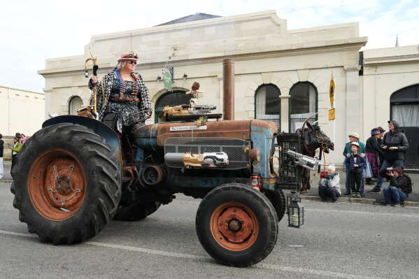 A participant rides a tractor during a parade at the Steampunk NZ Festival in Ōamaru, New Zealand, on May 30, 2026. (AP Photo/Charlotte Graham-McLay)