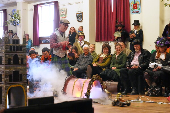 Lukas Hazlehurst drives a remote-controlled vehicle around an obstacle course during a teapot racing contest at the Steampunk NZ Festival in Ōamaru, New Zealand, Saturday, May 30, 2026. (AP Photo/Charlotte Graham-McLay)