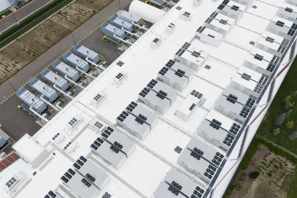 Fans, part of a cooling system, are visible on the roof of a data center April 27, 2026, in Hillsboro, Ore. (AP Photo/Jenny Kane, File)