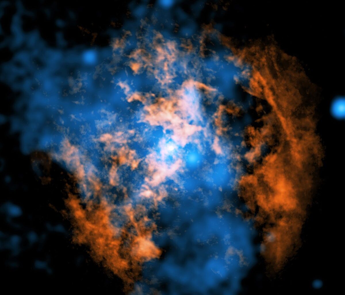 A composite image showing evidence for a wind blowing away from Sagittarius A* the supermassive black hole at the centre of our galaxy. The white dot in the centre is the black hole. Orange shows data from the Atacama Large Millimeter/Submillimeter Array, while blue is Chandra X-ray data. A cone-shaped cavity is visible as an absence of cold gas in the ALMA data, filled by hot X-ray-emitting gas in the Chandra data. X-ray: NASA/CXC/Northwestern Univ./M. Gorski; Radio: ESO/NAOJ/NRAO/ALMA; Image processing: NASA/CXC/SAO/K. Arcand and P. Edmonds