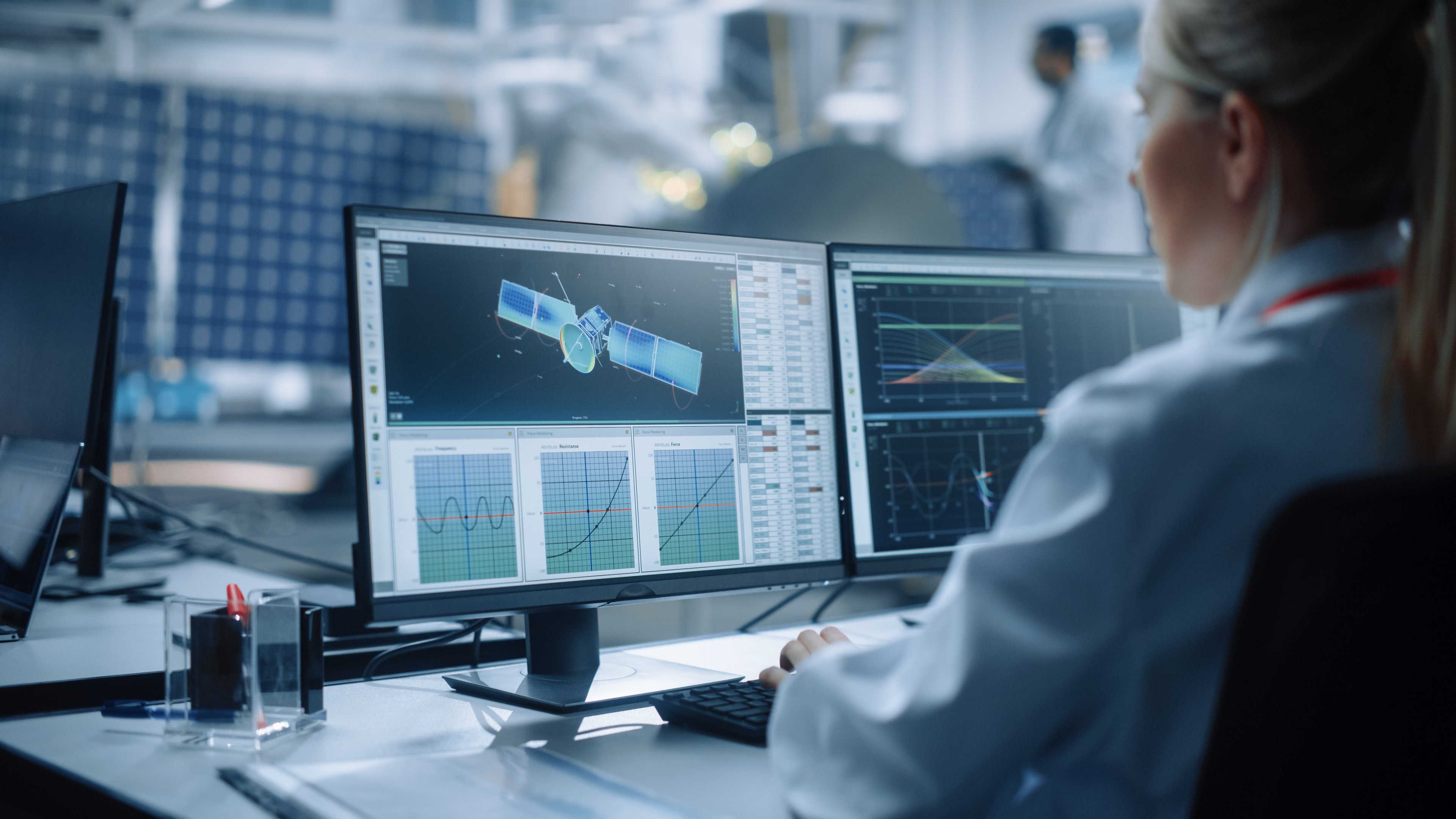 An engineer designing a satellite at their desk.